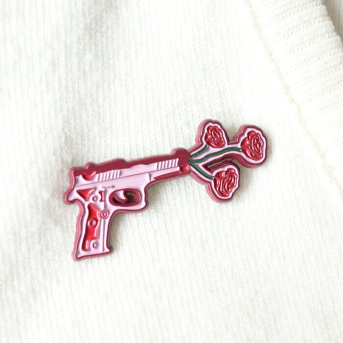 Geweer met bloemen pin